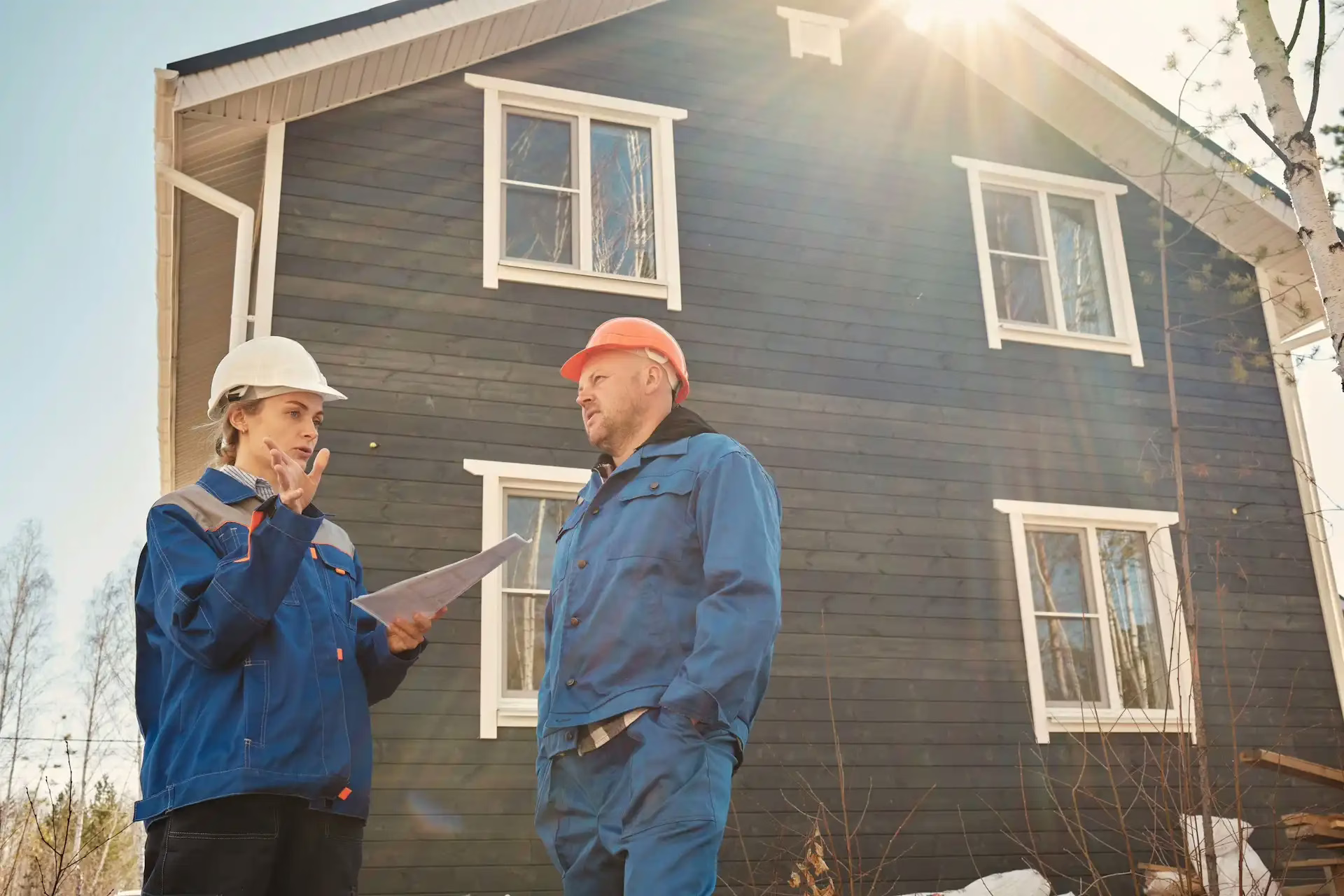 a man and a woman in hard hats on a construction site discussing cash flow